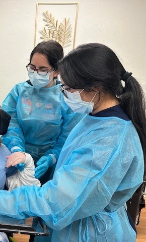 Ensz (left) and other dental team member assist with patient