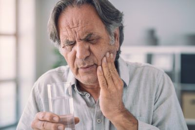 Man with toothache touches cheek