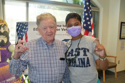 Veteran and dental hygienist stand smiling