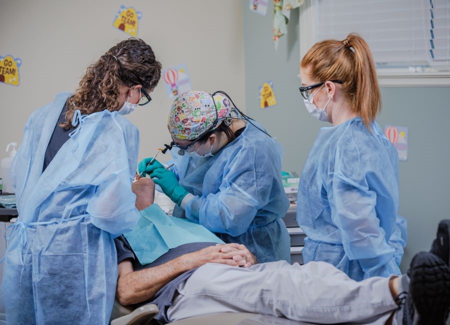 dental team cleans patient's teeth