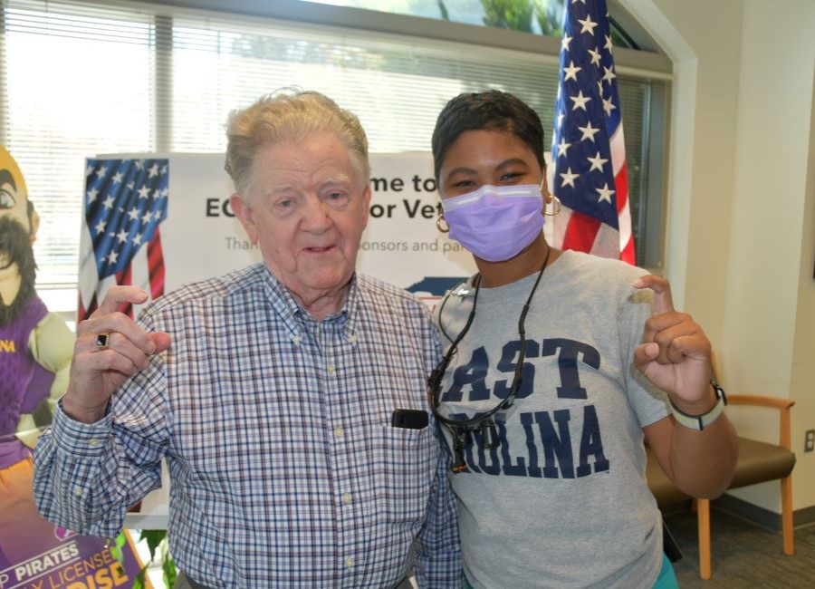 Veteran and dental hygienist stand smiling