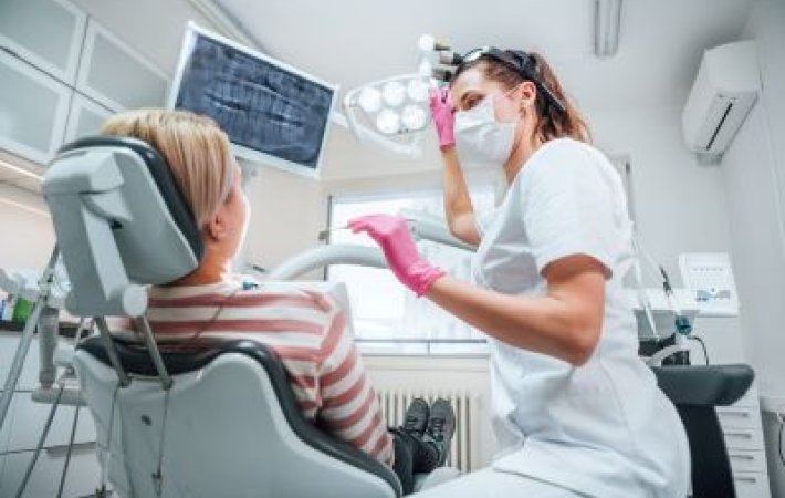 Dental team members shows x-ray to patient