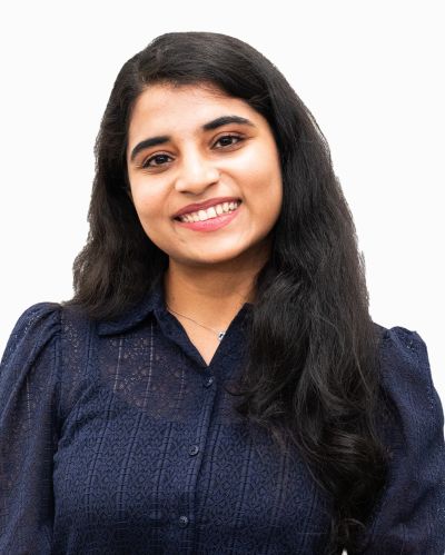 Smiling Woman with Long Dark Hair Wearing a Navy Blue Blouse Against a White Background.
