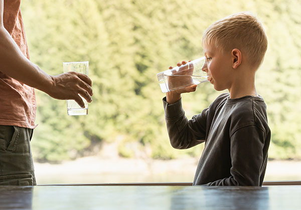 Parent and child drinking cup of water