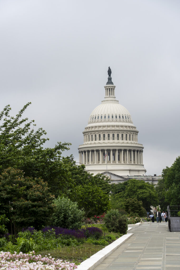 OPEN Hill Day Appointments_85 – CareQuest Institute U.s. Capitol Dome Visible Above Greenery and a Winding Path with People in the Distance.